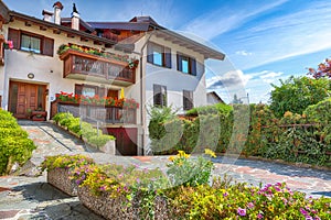 Awesome View of Traditional alpine houses with flowers on balcony the Cles city