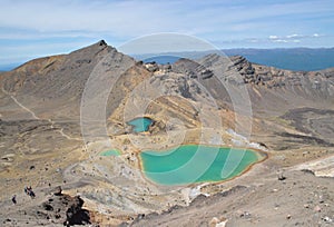 Awesome view of the vulcanic green lakes on the alpine mountain in the Tongariro National Park, hikers Walking down the track
