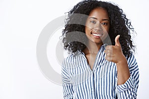 Awesome well done. Pleased satisfied supportive female dark-skinned friend wearing striped blouse smiling affirmative