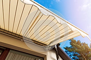 Awning over balcony window against blue sky photo