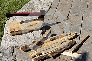 An ax and a pile of chopped firewood for a bonfire