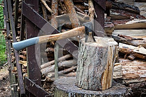An axe driven into a stump. Preparing firewood. Chopping wood on a stump