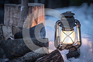Axe, firewood and lantern in the wilderness
