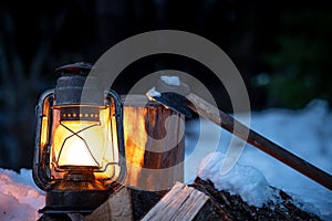 Axe, firewood and lantern in the wilderness