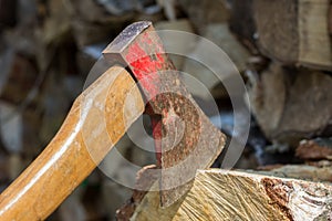 Axe in front of a stack of wood