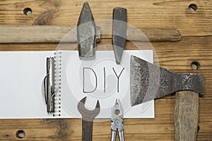 An axe and a hammer on his jeans and a white notebook on the top