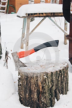 axe with handle stack in the chopped wood in winter