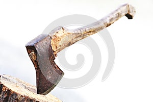 Axe in a log over white background