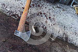 an axe near the wall with the blood drops, slaughterhouse, cutting pig concept