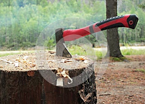 An axe with a red handle in a chock