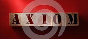 AXIOM word made with building blocks on red background. Basic principles in education and business concept