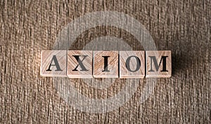 AXIOM word written on wooden blocks on a brown background