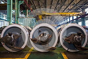 Axles with wheels of railway cars lie in a row at a repair plant