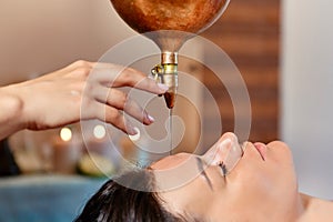 Ayurvedic Shirodhara procedure. Indian massage on the ancient technique of Shirodhara. The best of Indian massage photo