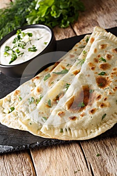 Azerbaijani food: flatbread qutab with greens and yogurt close-u