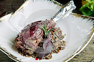 Azerbaijani Turkey leg with raw rice on a plate
