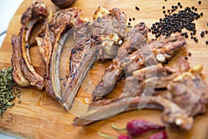 Azeri national antrikot kebab on a wooden board . Dry Satureja . Dried savory spice Satureja hortensis . Copper pepper dish .