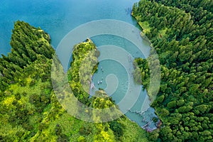 Azores scenic aerial drone landscape, Flores island. Iconic lagoon with several waterfalls on a single rockface, flowing into lake