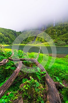 Azores scenic landscape, Flores island. Iconic lagoon with several waterfalls on a single rockface, flowing into lake Alagoinha photo