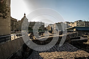 Aztec Temple Templo Mayor at ruins of Tenochtitlan with the Dome of Metropolitan Cathedral on background - Mexico City, Mexico photo