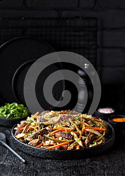 Azu - traditional tatar stew. Beef meat stew with vegetables and pickles on a black background