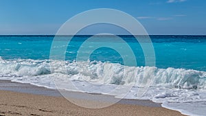 Azure breaking waves on beach, island in Greece