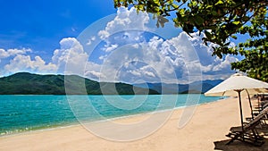 azure sea green islands beach umbrellas chairs on foreground