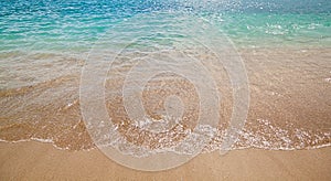 Azure sea waves with yellow sand beach. Bright sun light and beautiful sea.