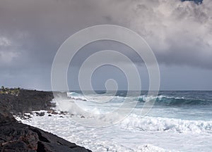 Azure wave crashes on black lava on Kaimu Beach, Hawaii, USA