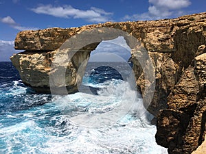 Azure window in the form of a natural arch of limestone rock in the Mediterranean Sea
