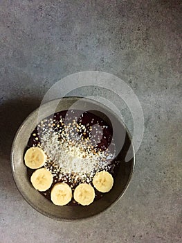 AÃ§ai-beet-raspberry smoothie bowl with coconut, buckwheat, banana slices