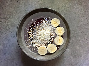 AÃ§ai-beet-raspberry smoothie bowl with coconut, buckwheat, banana slices