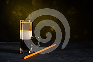 B-52 cocktail shot and straw on dark gray concrete background