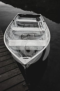 B&W of rowboat by dock.