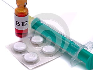 B12 ampoule with syringe and tablets isolated