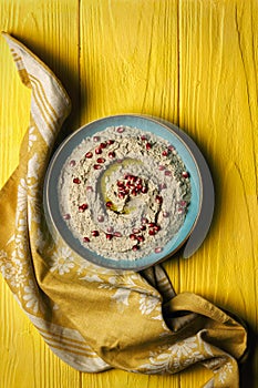 Baba ganoush or mutabal, Middle Eastern eggplant dip sauce garnished with pomegranate seeds with a rustic napkin