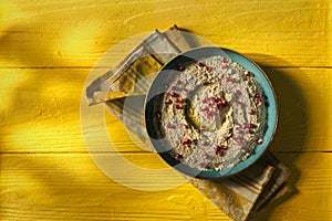 Baba ganoush or mutabal, Middle Eastern eggplant dip sauce garnished with pomegranate seeds with a rustic napkin