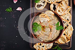 Baba ghanoush vegan hummus from eggplant with seasoning, parsley and toasts.