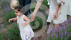 Babby daughter running with parents in lavender field.