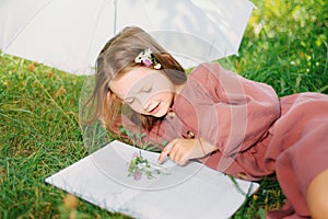 Babe with a flower reads a book in the park