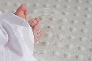 Babies feet sticking out of a baptism outfit