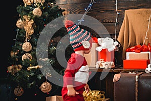 Babies. Happy small kids in santa hat with present have a christmas. Portrait kid with gift on wooden background. Winter