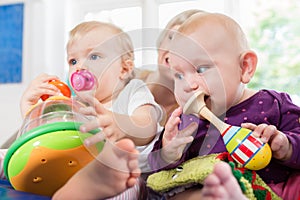 Babies with pacifier in toddler group playing with toys