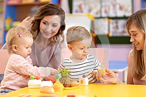 Babies playing with toys in nursery room montessori school