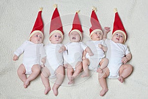 Babies with santa hats on bright background