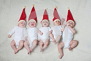 Babies with santa hats on bright background
