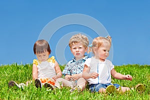 Babies sit on grass