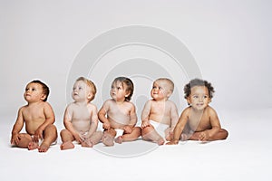 Babies Sitting Side By Side Looking Away