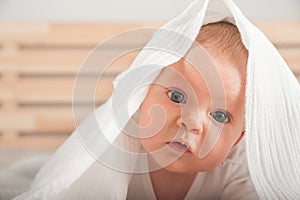 Baby 3 months old close up and copy space. Baby in a white muslin diaper or towel at home. Newborn care and upbringing concept