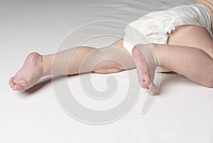 Baby (6-12 months) crawling on bed close up of feet